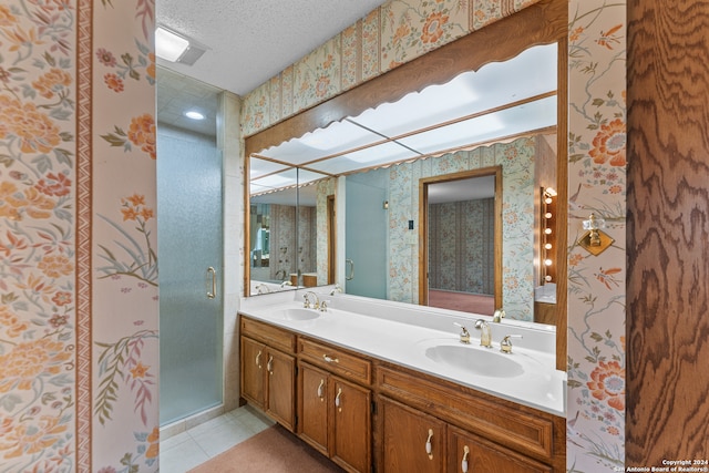 bathroom with tile patterned floors, walk in shower, a textured ceiling, and vanity