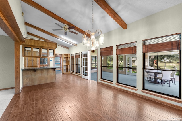 unfurnished living room featuring high vaulted ceiling, hardwood / wood-style floors, ceiling fan with notable chandelier, and beamed ceiling