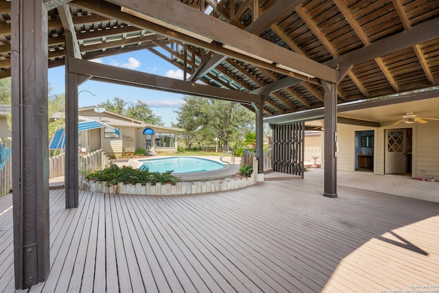 wooden terrace featuring a fenced in pool and ceiling fan