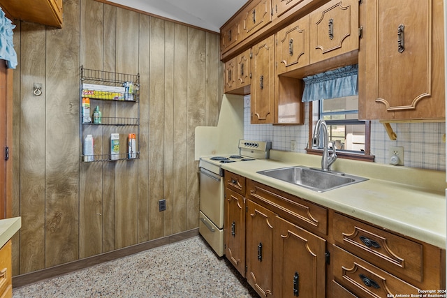 kitchen featuring backsplash, range, and sink