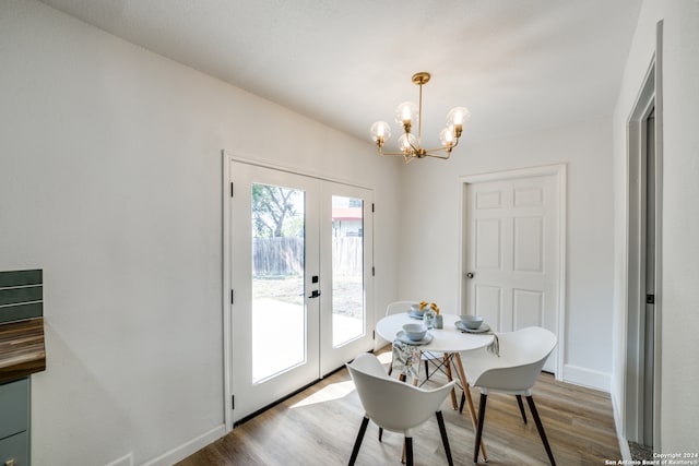 dining space featuring hardwood / wood-style floors, a chandelier, and french doors