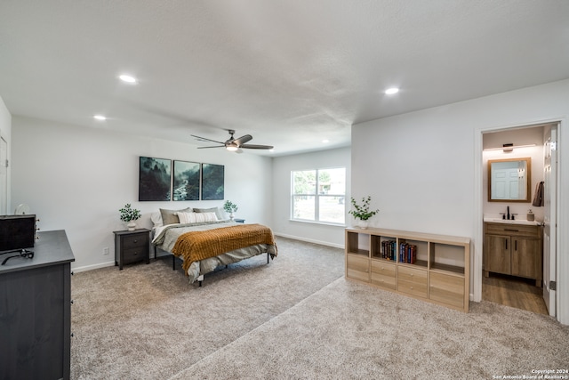 carpeted bedroom featuring ceiling fan, sink, and ensuite bath