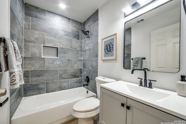 full bathroom featuring tiled shower / bath, toilet, and vanity