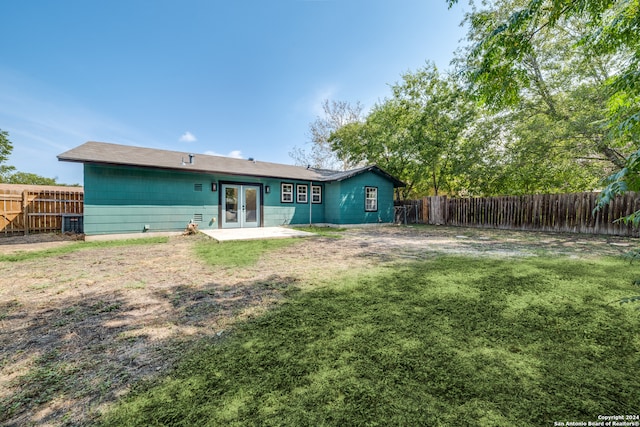 back of property featuring french doors and a lawn