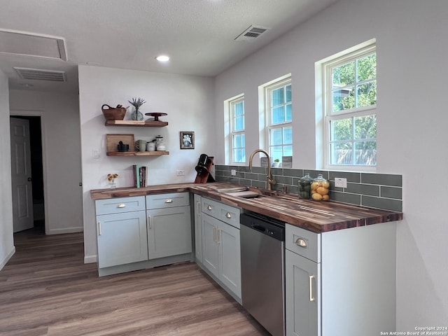 kitchen featuring gray cabinets, dishwasher, wooden counters, decorative backsplash, and dark wood-type flooring