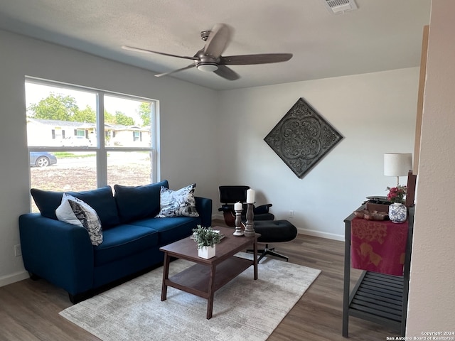 living room featuring ceiling fan and dark hardwood / wood-style floors