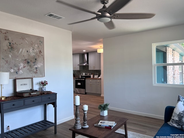 living room with a textured ceiling, ceiling fan, and dark hardwood / wood-style flooring