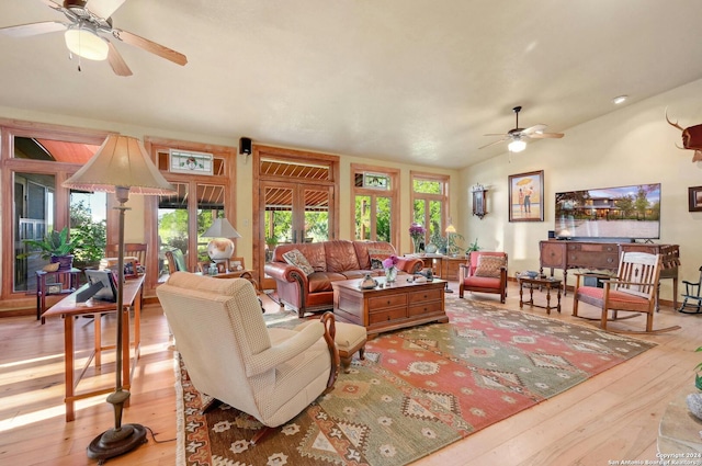 living room featuring ceiling fan, light wood-type flooring, and vaulted ceiling