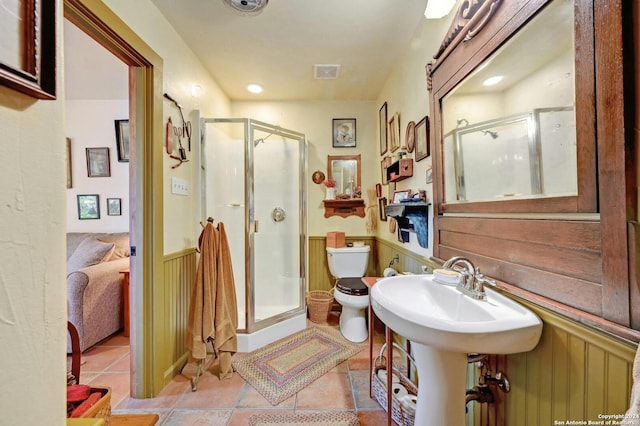 bathroom featuring toilet, tile patterned floors, and walk in shower