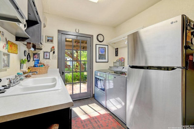 kitchen featuring washer and dryer, sink, and stainless steel fridge