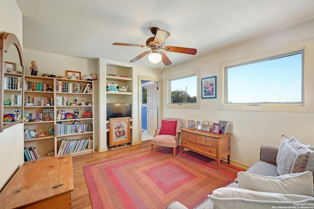 living area with hardwood / wood-style floors and ceiling fan