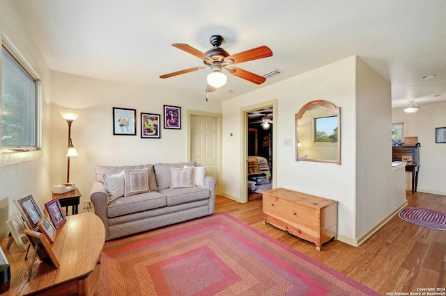 living room featuring ceiling fan and light hardwood / wood-style flooring