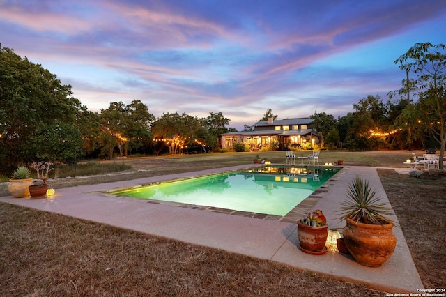 pool at dusk with a patio