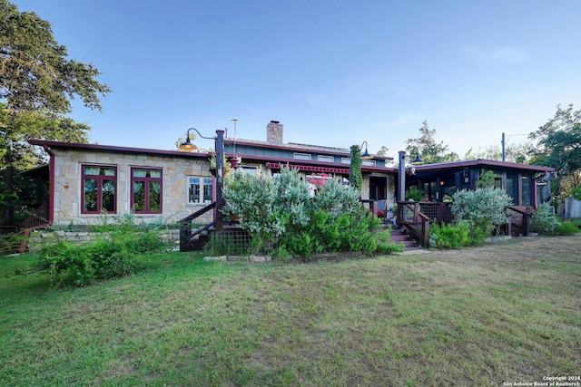 rear view of house featuring a lawn