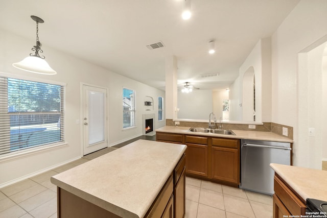 kitchen with ceiling fan, sink, a center island, hanging light fixtures, and stainless steel dishwasher