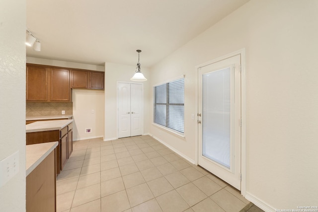 kitchen featuring pendant lighting, light tile patterned floors, and tasteful backsplash