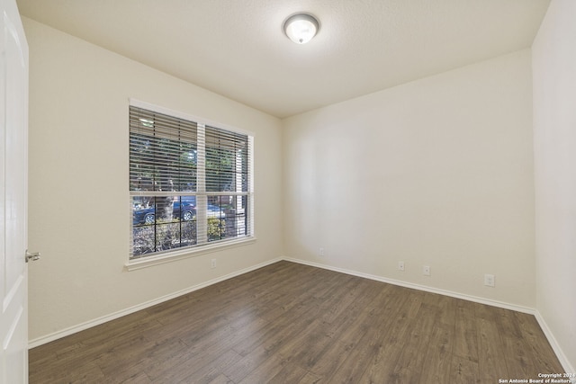 unfurnished room featuring dark wood-type flooring