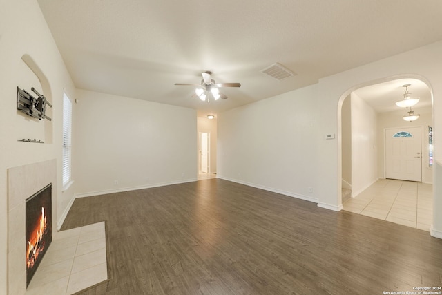 unfurnished living room featuring a fireplace, ceiling fan, and hardwood / wood-style floors