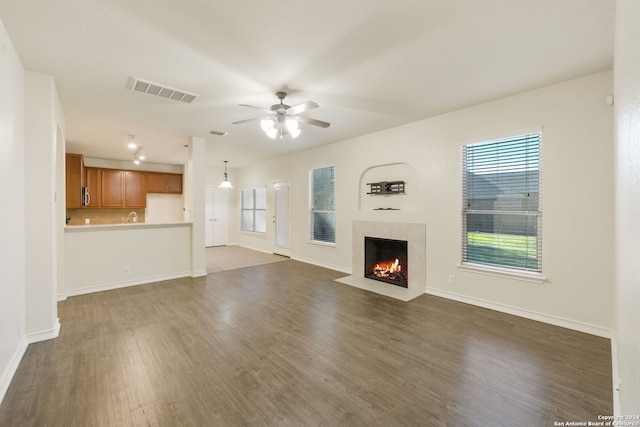 unfurnished living room with dark hardwood / wood-style floors and ceiling fan