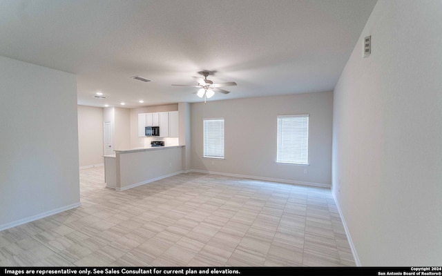 unfurnished living room featuring a textured ceiling and ceiling fan