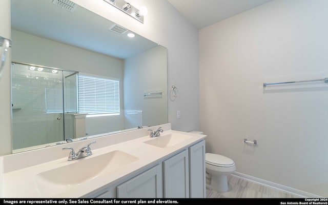 bathroom with a shower with shower door, toilet, hardwood / wood-style floors, and vanity