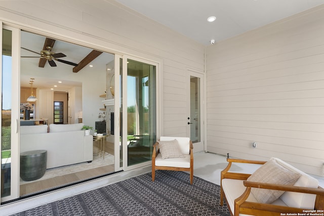 sunroom / solarium featuring beam ceiling and ceiling fan