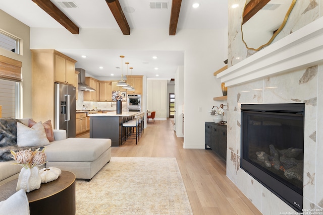 living room with light wood-type flooring and beamed ceiling