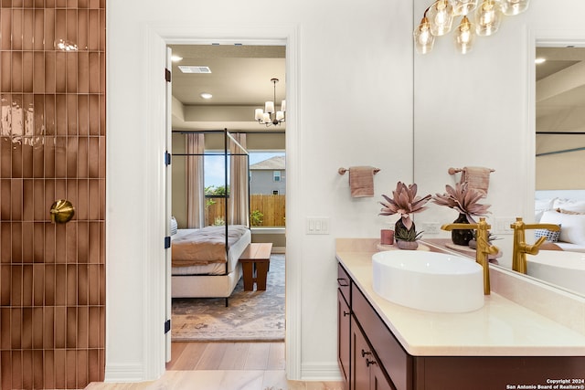 bathroom with vanity, an inviting chandelier, and hardwood / wood-style floors