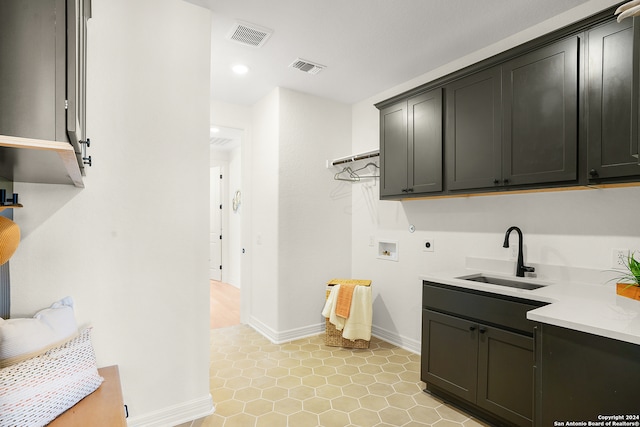 washroom with hookup for a washing machine, cabinets, sink, and hookup for an electric dryer