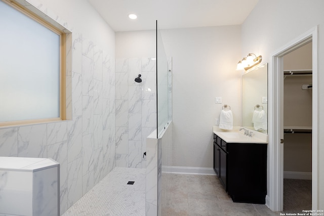 bathroom featuring vanity, tile patterned flooring, and a tile shower