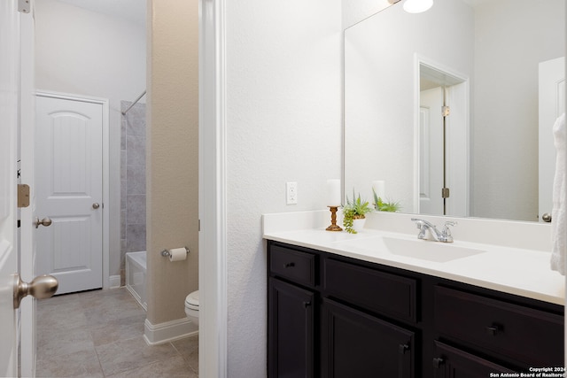 full bathroom with tiled shower / bath, vanity, tile patterned flooring, and toilet