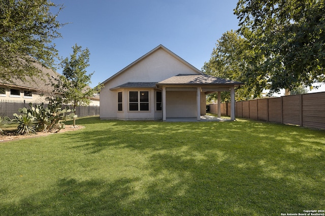 rear view of house featuring a lawn and a patio