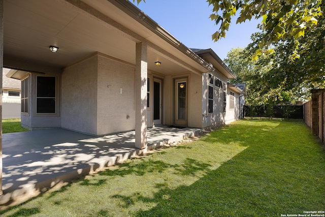 entrance to property featuring a patio area and a yard