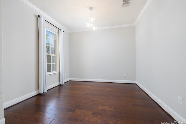 spare room with ornamental molding, dark hardwood / wood-style floors, and a chandelier