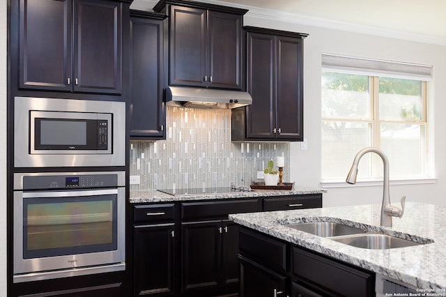 kitchen featuring decorative backsplash, stainless steel appliances, crown molding, and sink