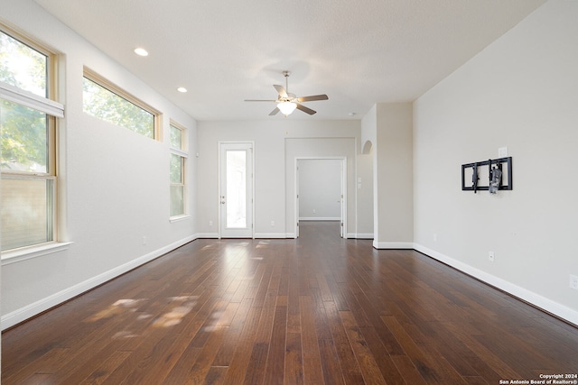 unfurnished living room featuring ceiling fan, a textured ceiling, and dark wood-type flooring