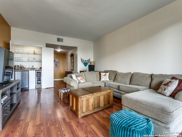 living room featuring wine cooler, indoor bar, and dark hardwood / wood-style floors