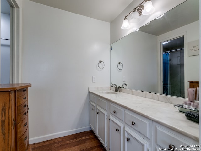 bathroom with a shower with shower curtain, hardwood / wood-style flooring, and vanity