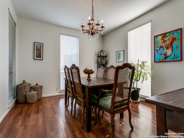 dining room featuring dark wood-type flooring, plenty of natural light, and a chandelier