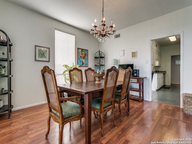 dining room with hardwood / wood-style floors, a notable chandelier, and sink