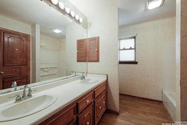 bathroom featuring vanity, hardwood / wood-style flooring, and bathtub / shower combination