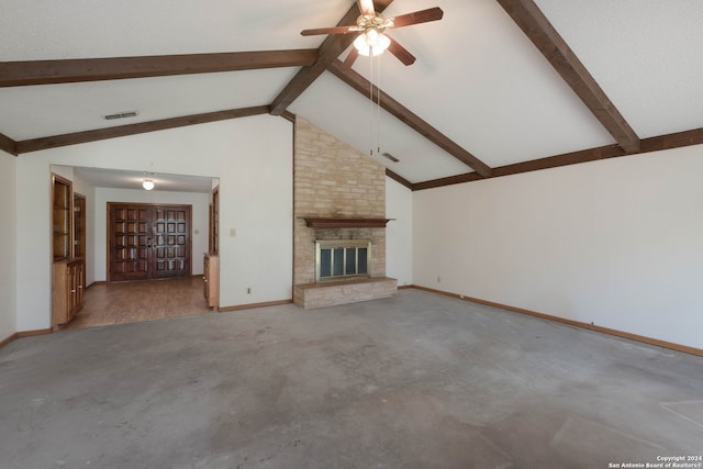 unfurnished living room featuring a fireplace, beamed ceiling, concrete flooring, and ceiling fan