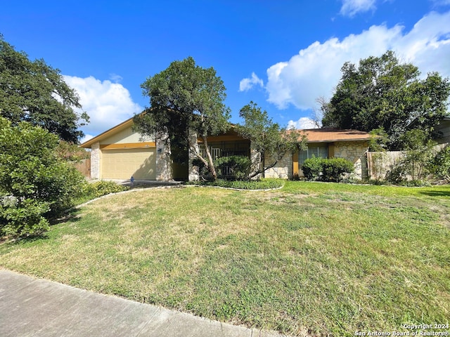 ranch-style home with a garage and a front lawn