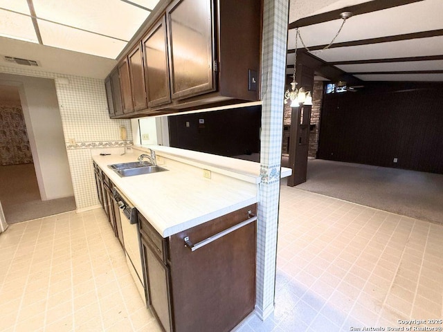 kitchen with sink, white dishwasher, and dark brown cabinetry