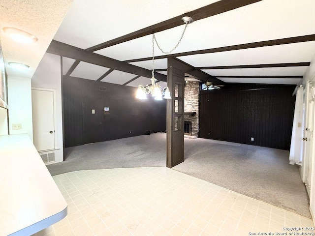 basement featuring ceiling fan with notable chandelier, wooden walls, carpet floors, and a brick fireplace