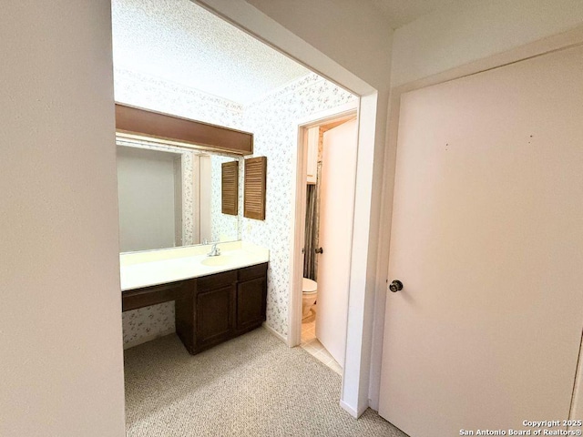 bathroom featuring vanity, toilet, and a textured ceiling