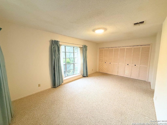 unfurnished bedroom featuring mail boxes, carpet, and a textured ceiling