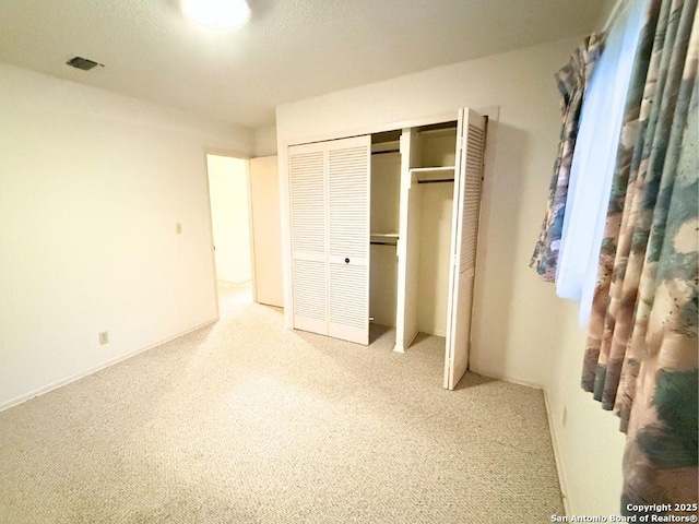 unfurnished bedroom featuring carpet and a closet