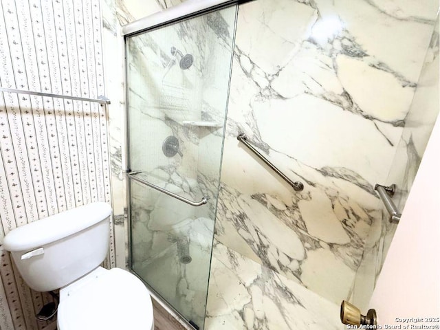 bathroom featuring a shower with shower door, toilet, and wood-type flooring