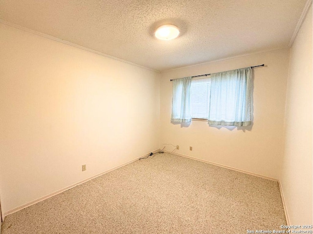 carpeted spare room featuring ornamental molding and a textured ceiling